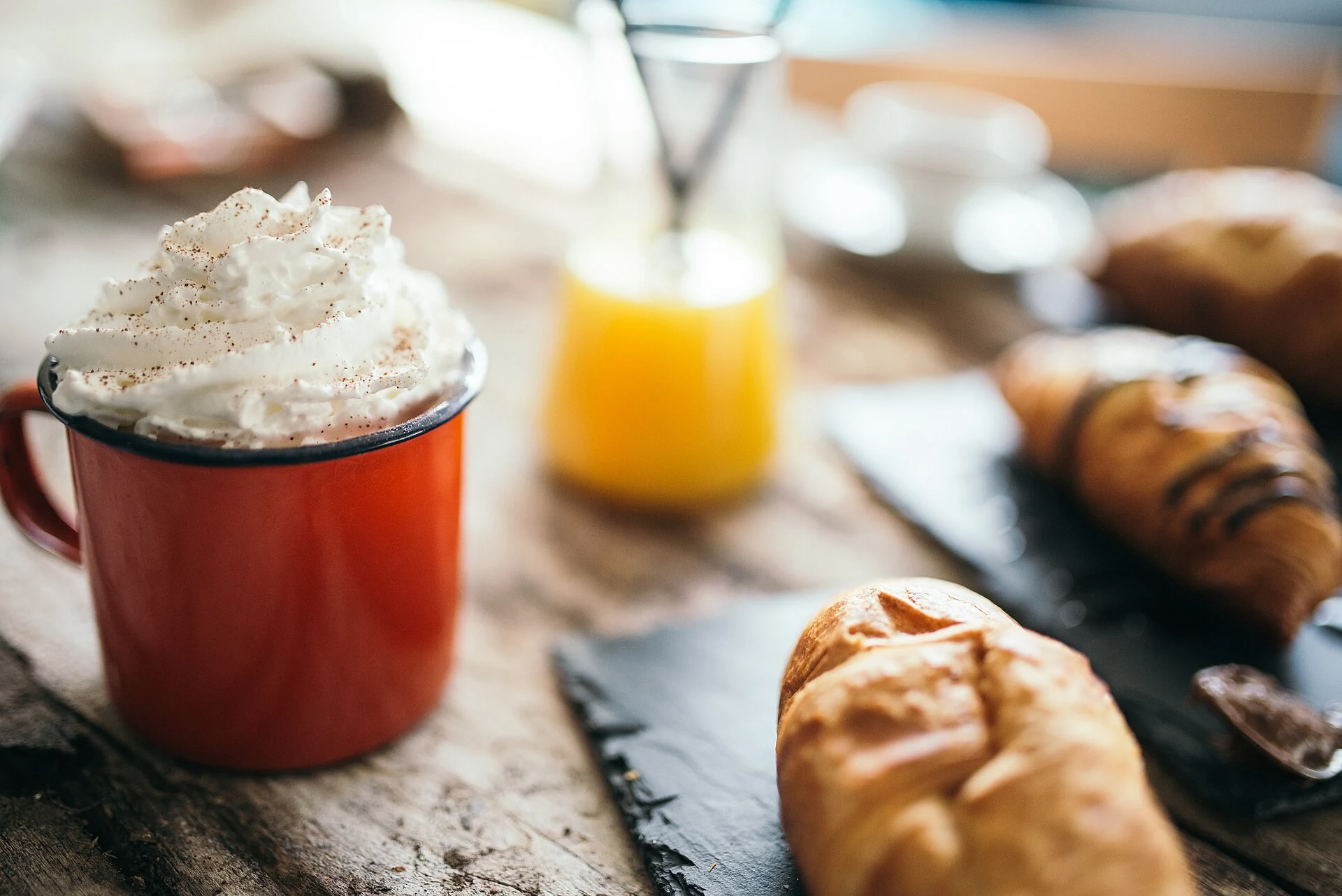Warm coffee and pastries on a wooden café table